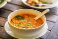 Tom Yam Kung, Thai cuisine. on a wooden table. Background - other Thai dishes