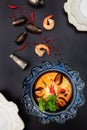 Tom Yam soup in a blue textured plate. Photo on a dark background. Copy of the space. Excellent serving of this dish. Top view.The Royalty Free Stock Photo