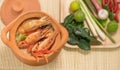 Tom Yum Goong in a clay pot spicy soup traditional thai food cuisine in Thailand on mat wicker background,Tom Yum Kung,Thai Food Royalty Free Stock Photo