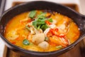 Tom Yum Goong Tom Yum Kung, Traditional Thai Sour and Spicy Tiger Prawn Soup on wooden tray, famous seafood shrimp or prawn dish