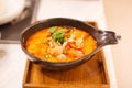 Tom Yum Goong Tom Yum Kung, Traditional Thai Sour and Spicy Tiger Prawn Soup on wooden tray, famous seafood shrimp or prawn dish