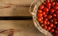 Tomates-cereja vermelhos pequenos dentro de cesta caixote de madeira em estilo rÃÂºstico, foco seletivo