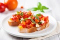 tomato and basil bruschetta on a white ceramic plate Royalty Free Stock Photo