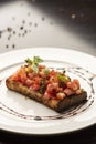 Tomato bruschetta with basil and parsley on white plate Royalty Free Stock Photo