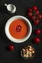 tomato cream soup in white bowl on black desk . Royalty Free Stock Photo