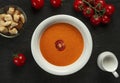 tomato cream soup in white bowl on black desk . Royalty Free Stock Photo