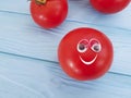 Tomato funny organic ingredient nature concept person eyes cartoon on blue wooden positive emotion