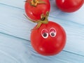 Tomato funny organic ingredient concept person eyes cartoon on blue wooden positive emotion