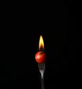 Tomato on fire with blue flames isolated on black background Royalty Free Stock Photo