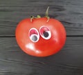 Tomato funny cartoon on black wooden funny