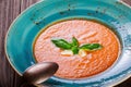 Tomato gazpacho soup with basil, feta cheese, ice and bread on dark wooden background, Spanish cuisine. Ingredients on table. Royalty Free Stock Photo