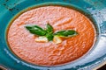 Tomato gazpacho soup with basil, feta cheese, ice and bread on dark wooden background, Spanish cuisine. Ingredients on table. Top Royalty Free Stock Photo