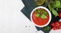 Tomato gazpacho soup in a ceramic bowl topped with basil leaves