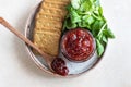 Tomato jam, confiture or sauce in glass jar with crackers and green leaves salad. Unusual savory jam. Mediterranean cuisine. Top Royalty Free Stock Photo