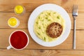 Tomato juice in cup, saltÃÂ± pepper, plate with cutlet and mashed potato, fork on table. Top view Royalty Free Stock Photo