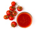 Tomato juice in a glass and a branch of red tomatoes on a white background. Royalty Free Stock Photo