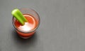 Tomato juice in a glass with celery stick on gray wooden background Royalty Free Stock Photo