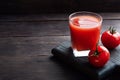 Tomato juice in glass glasses and fresh ripe tomatoes on a branch. Dark wooden background with copy space. Royalty Free Stock Photo