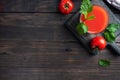 Tomato juice in glass glasses and fresh ripe tomatoes on a branch. Dark wooden background with copy space. Royalty Free Stock Photo