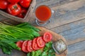 Tomato juice, a large branch of ripe red tomatoes on a wooden Board with leaves of ramsonand dill in a rustic style Royalty Free Stock Photo