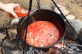 Tomato juice and meat in caldron