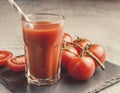 Tomato juice in a tall glass, paper straw, stone plate