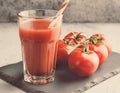 Tomato juice in a tall glass, paper straw, stone plate