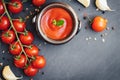 Tomato ketchup sauce in a bowl with spices, garlic and cherry tomatoes on dark background. View from above. Royalty Free Stock Photo