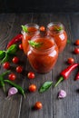 Tomato ketchup sauce with cherry tomatoes and red hot chili peppers, garlic and herbs in a glass jar on dark background. Royalty Free Stock Photo