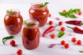 Tomato ketchup sauce with cherry tomatoes and red hot chili peppers, garlic and herbs in a glass jar on white background. Royalty Free Stock Photo