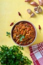 Tomato lobio of green bean pods in a bowl on a bright yellow background. Flat lay, top view