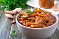 Tomato lobio of green bean pods in a bowl on a wooden background. Lenten dish. Close up