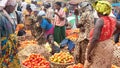 Tomato market in Uganda. Women in colorful dresses selling different tomatoes on street market.