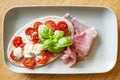 Tomato mozzarella pita on flatbread with fresh Parma ham and decorated with basil leaves Royalty Free Stock Photo