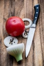 Knife on a wooden board. Together with tomato and onion.