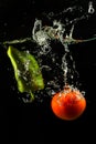 Tomato and paprika in water splash on black Royalty Free Stock Photo