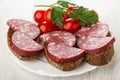 Tomato, parsley, sandwiches with smoked sausage in plate on wooden table Royalty Free Stock Photo