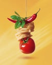 Tomato, pasta, pepper and basil on a rope, on a yellow Royalty Free Stock Photo