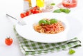 Tomato pasta spaghetti with fresh tomatoes, basil, italian herbs and olive oil in a white bowl on a white wooden background Royalty Free Stock Photo