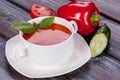 Tomato cold soup in a white plate on a wooden background Royalty Free Stock Photo