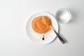 Tomato protein soup powder on a spoon. Glass of water. Meal replacement. Dry soup. Multivitamins, astaxanthin, fish oil, omega