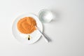 Tomato protein soup powder on a spoon. Meal replacement. Dry soup. Multivitamins, astaxanthin, fish oil, omega pills on a plate.