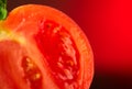 Tomato. Ripe natural tomatoe closeup. Organic tomato on red background. Half of Tomato close-up