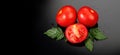 Tomato. Ripe natural tomatoes close-up. Organic tomato with leaves on black background Royalty Free Stock Photo