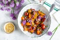 Tomato salad with chives flowers in a white bowl