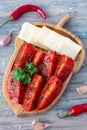 Tomato salad with hot peppers, olive oil and cheese on wooden plate