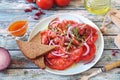 Tomato salad with red onion and spicy sauce of different varieties of tomatoes, two slices of rye bread Royalty Free Stock Photo
