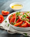 Tomato salad with spring onion and herbs in white bowl. Healthy summer food Royalty Free Stock Photo