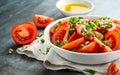 Tomato salad with spring onion and herbs in white bowl. Healthy summer food Royalty Free Stock Photo