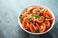 Tomato salad with spring onion and herbs in white bowl. Healthy summer food Royalty Free Stock Photo